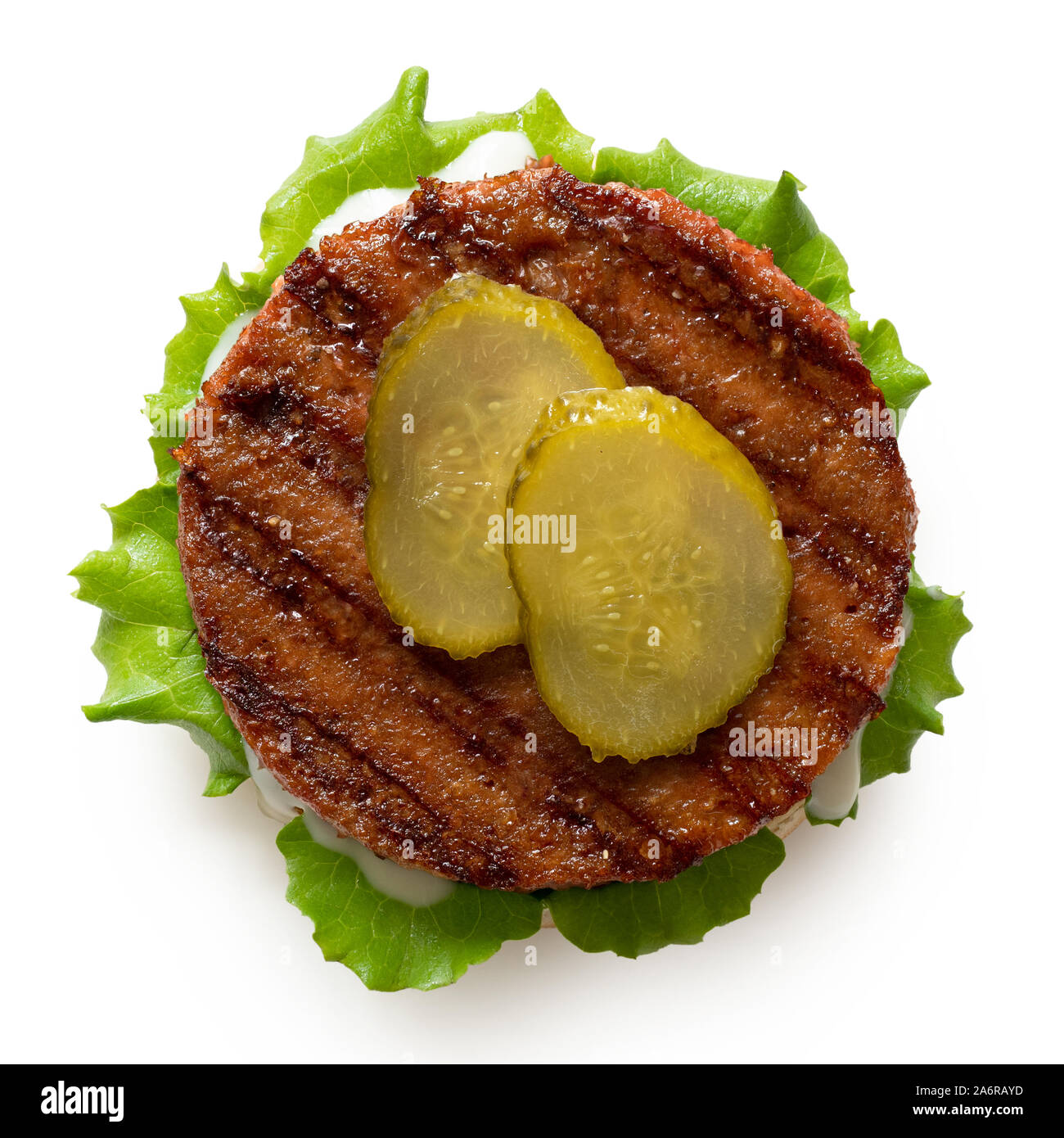 Freshly grilled plant based burger patty on bun with lettuce, slices of