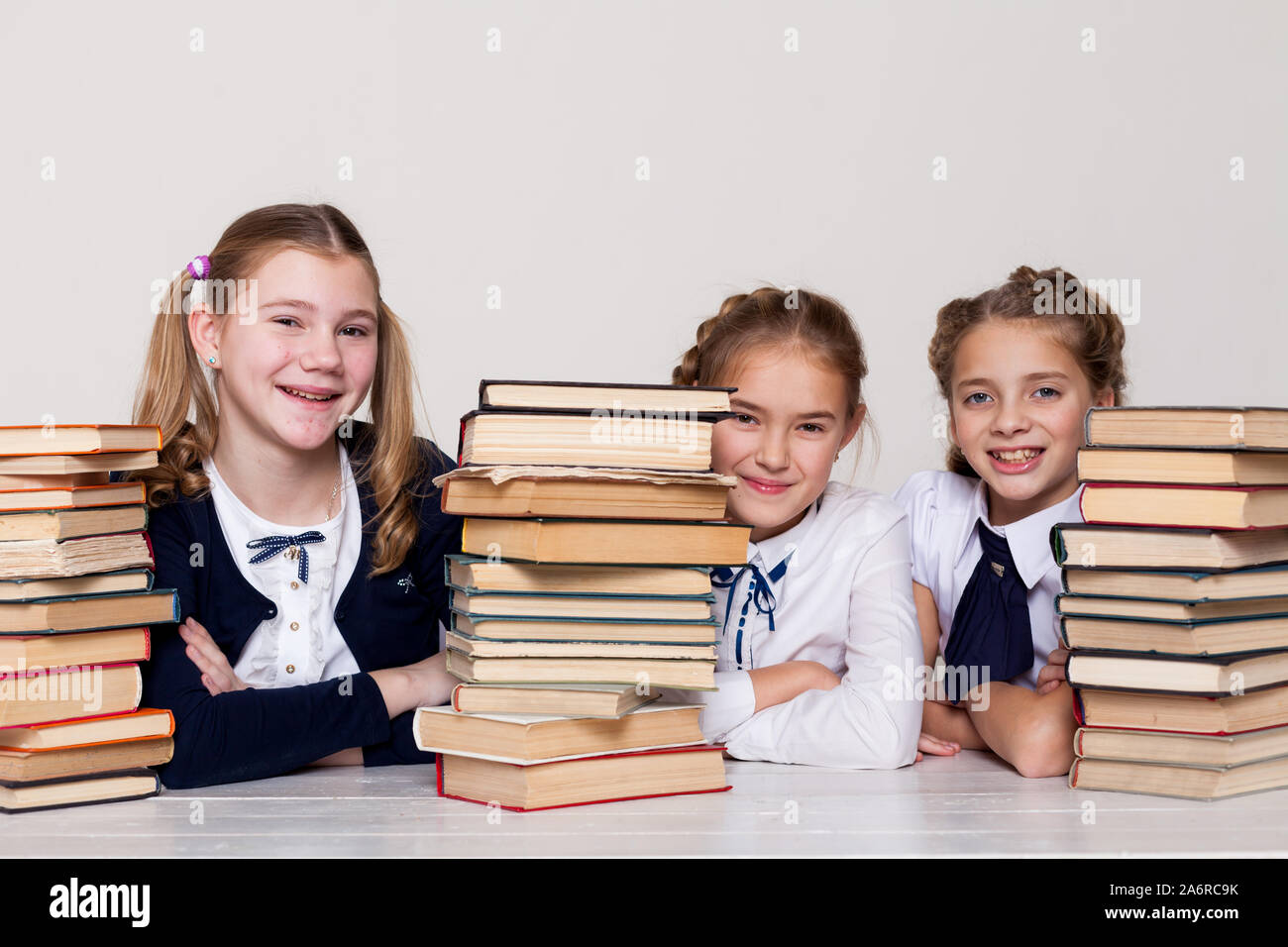 three schoolgirl girls at the desk with books in class Stock Photo - Alamy