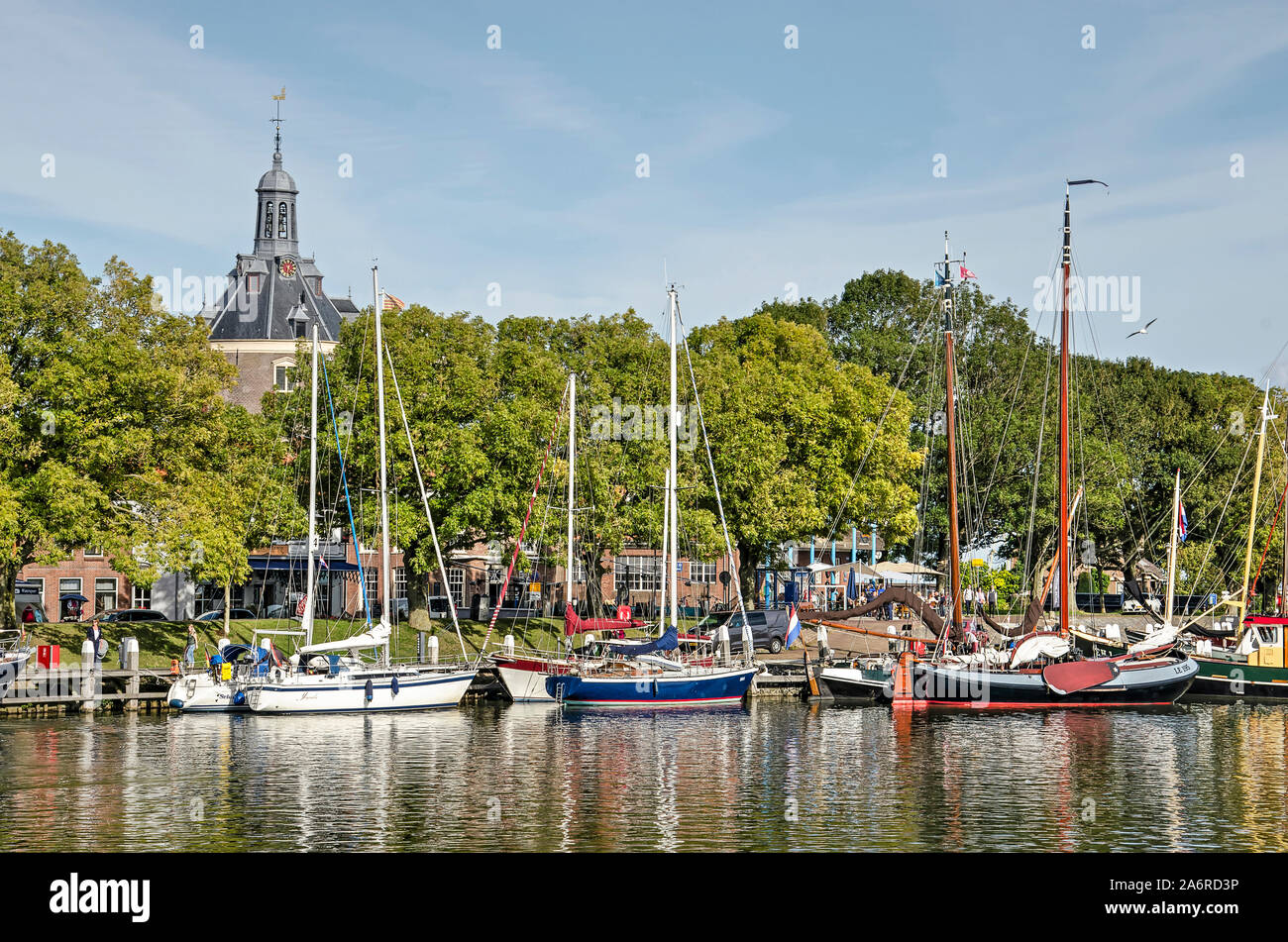 Enkhuizen, The Netherlands, September 13, 2019: view of the outer harbour with historic and modern vessels, trees in autumn colors and the tower of Dr Stock Photo