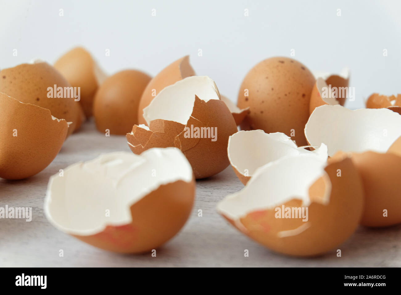View of broken brown eggs on grey background Stock Photo