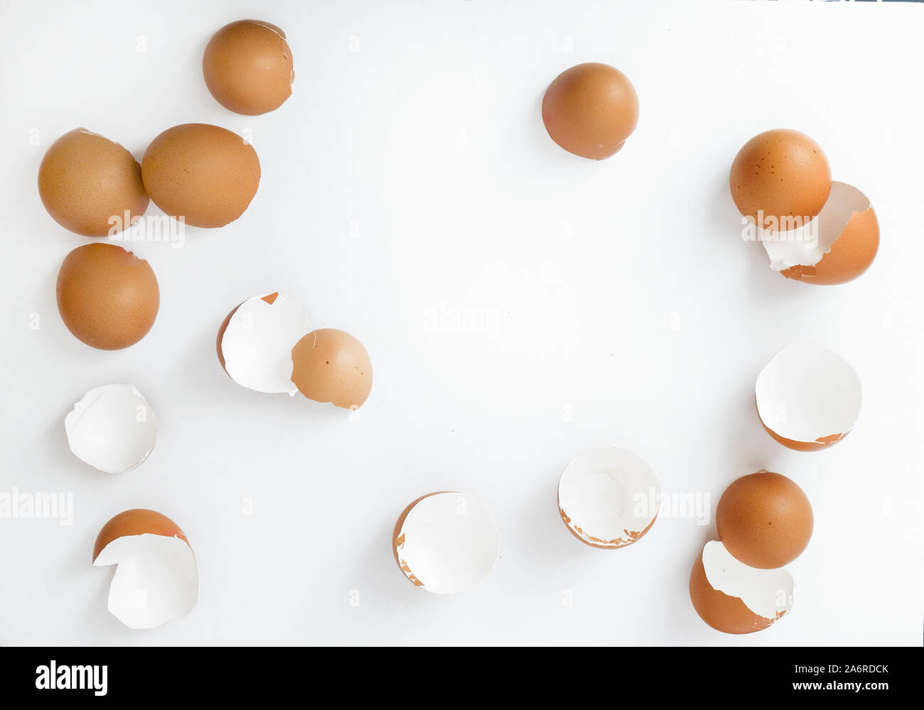 broken brown eggshells scattered on a white background Stock Photo