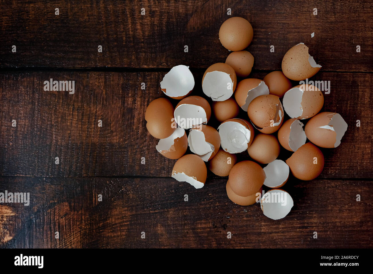 broken brown eggs on a wood background Stock Photo