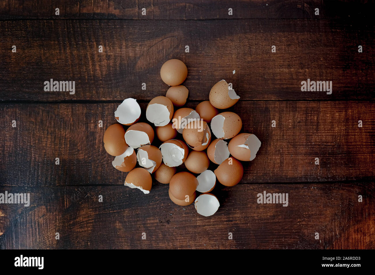 broken brown eggs on a wood background Stock Photo