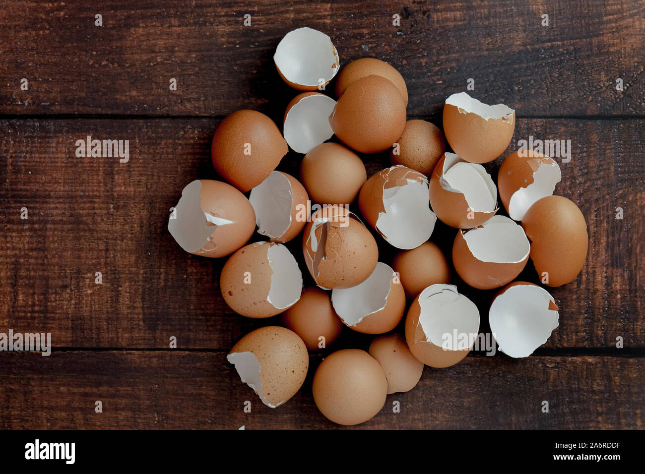 broken brown eggs on a wood background Stock Photo