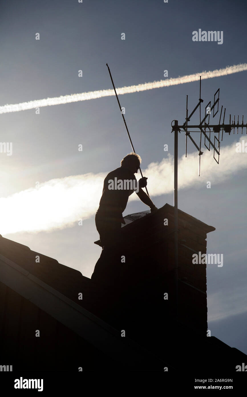 CHIMNEY SWEEP on roof Stock Photo