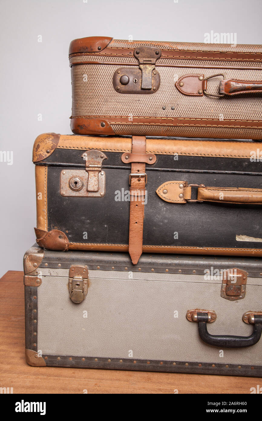 Old, retro, suitcases lie on the table with white background. Obsolete