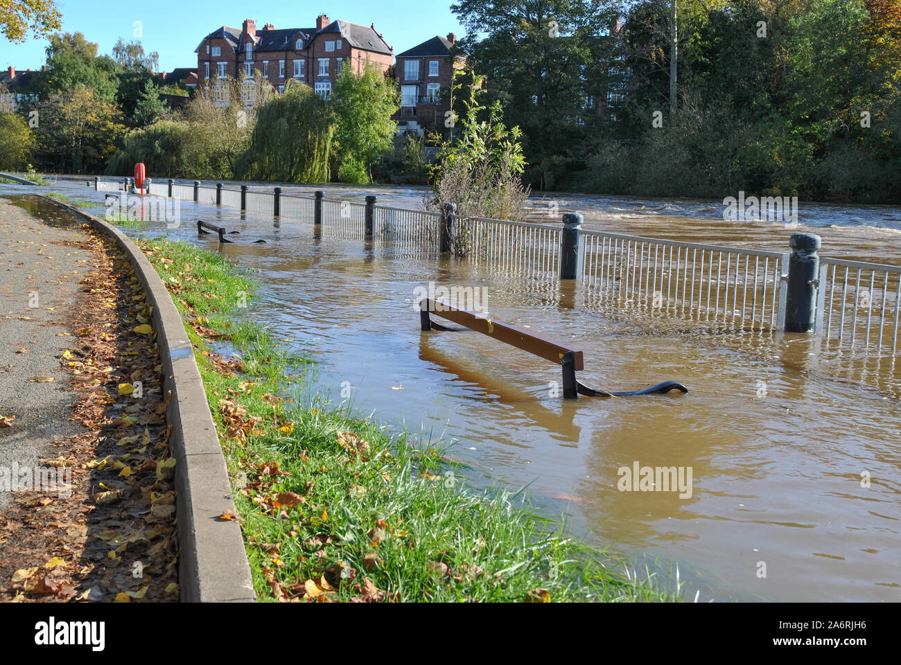 Submerged benches alongside the River Severn in Shrewsbury, Shropshire, UK after heavy rain caused flooding Stock Photo