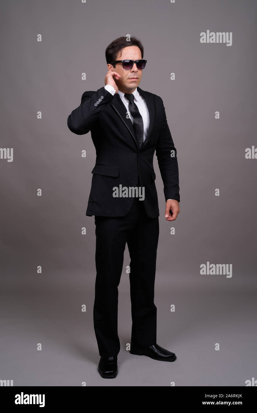 Full body shot of handsome Persian businessman with sunglasses Stock Photo