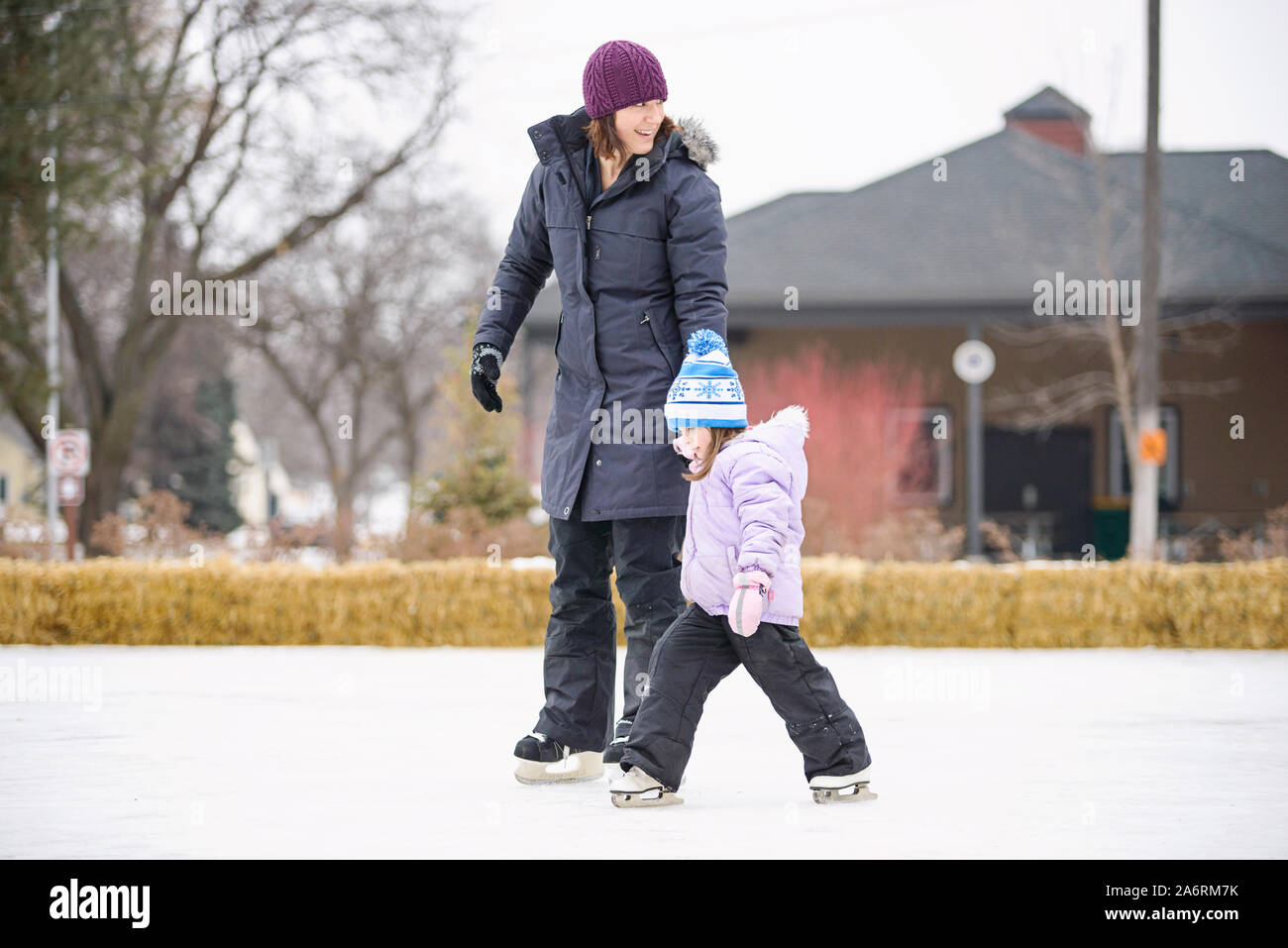 Mother Teaching Daughter to Ice Skate Stock Photo