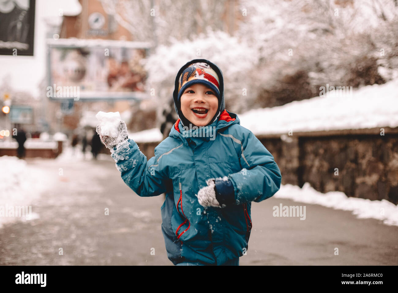 Boy holding snowball hi-res stock photography and images - Alamy