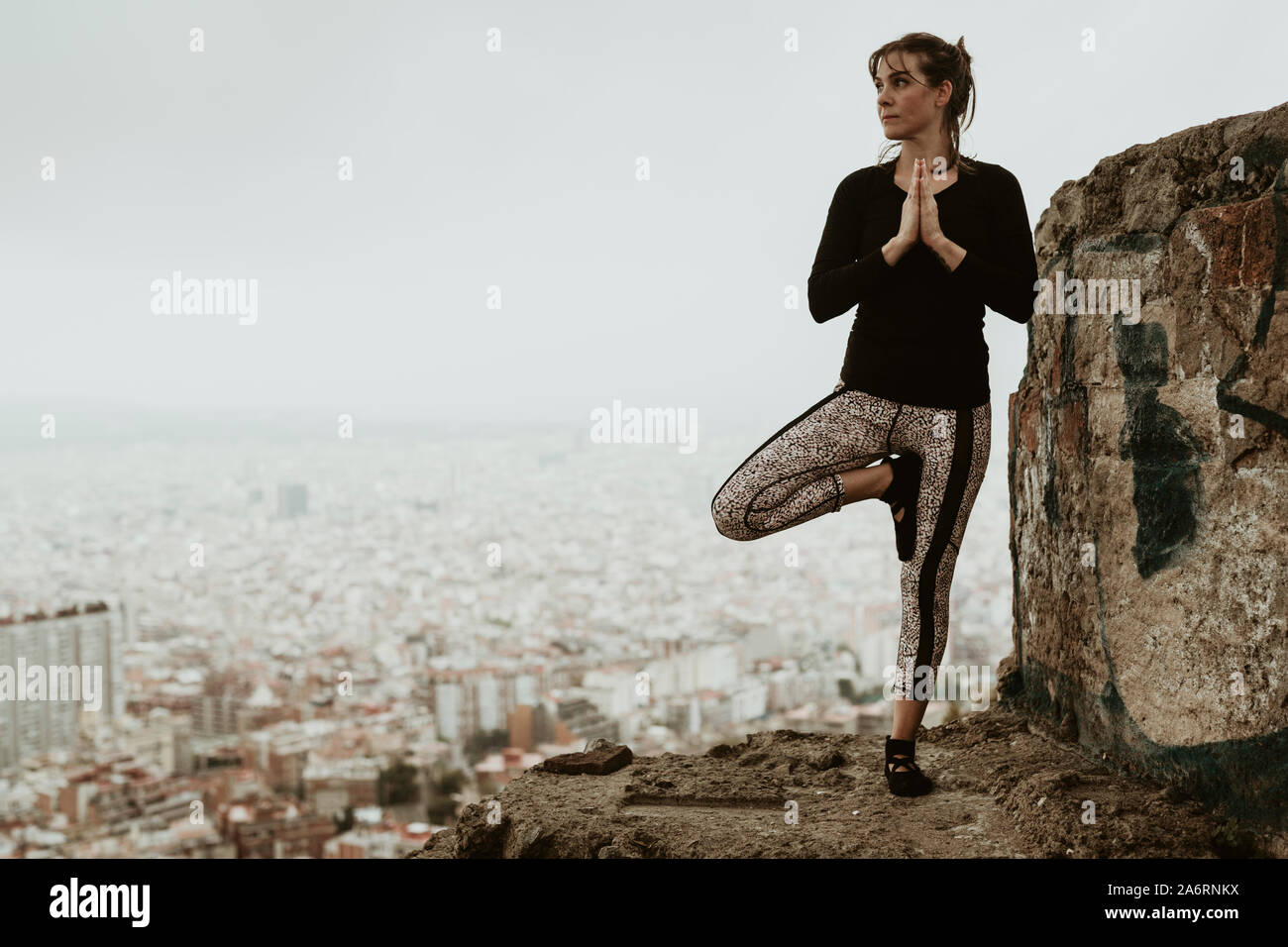 Young woman practicing yoga, asana looking at the city Stock Photo