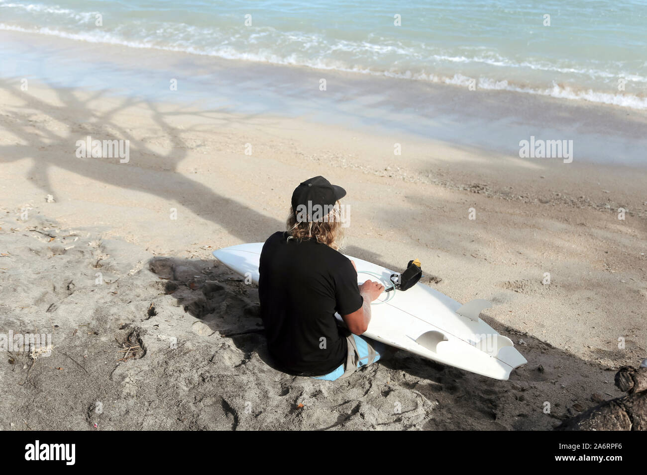 Title Surfer with surfboard at beach Stock Photo