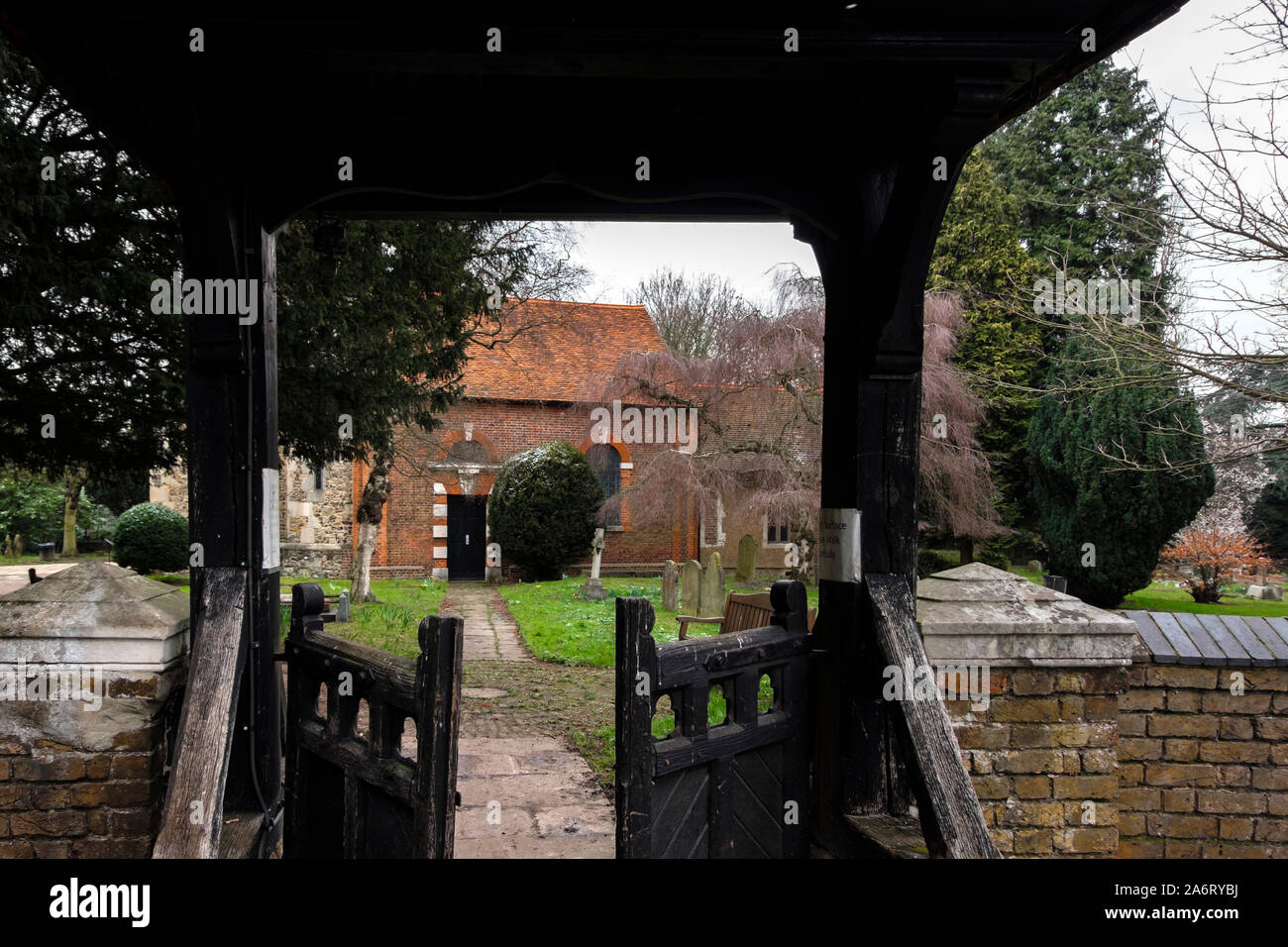 London, UK - March 17 2018: Entrance to St Dunstan's Church through a wooden gate, in Cranford Park. The oldest surviving part is its 15th-century tow Stock Photo