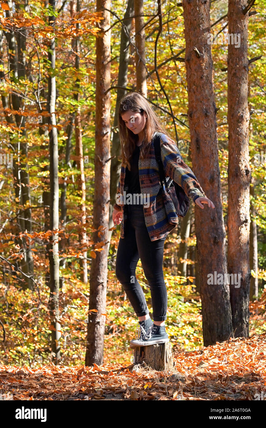 A Young Girl With A Backpack Through Autumn Forest Stock Photo