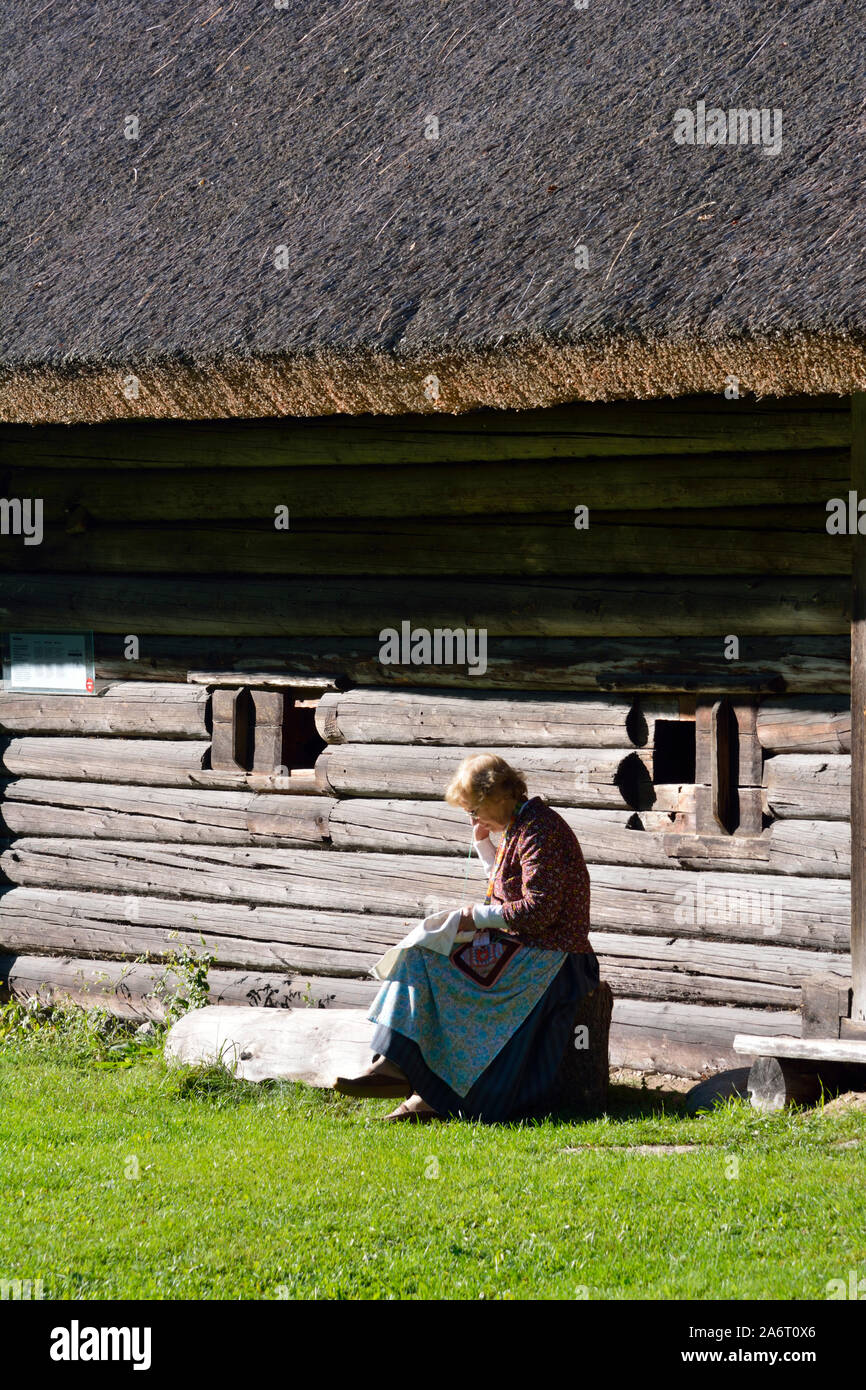 Woman making embroidery in a farmhouse. Estonian Open Air Museum, Rocca al Mare. Tallinn, Estonia Stock Photo