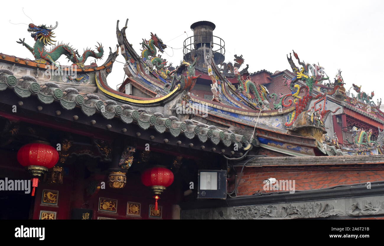 Ritual chimney for burning offerings and dozens of dragons guarding the roofs of the Tonghuai temple of the Chinese native religion in Quanzhou Stock Photo