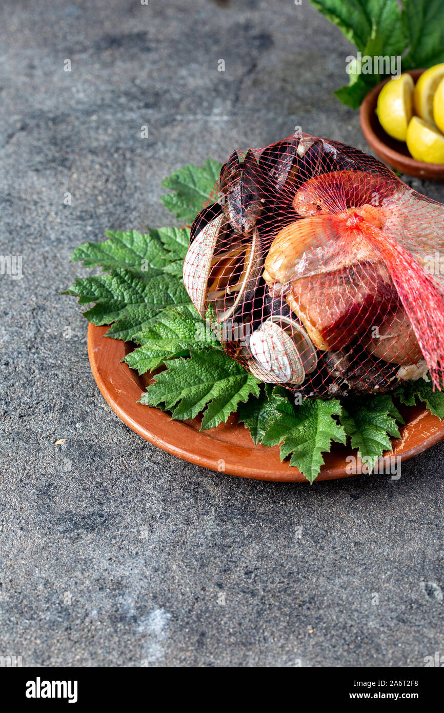 Famous traditional dish of the south of Chile and the Chiloe archipelago - Curanto al Hoyo, Kuranto. Different seafood, meat and potatoes milcao Stock Photo