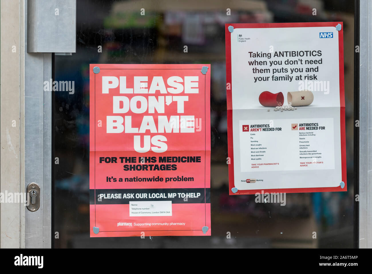 NHS medicine shortages. Poster in window of chemist stating Please don't blame us for the NHS medicine shortages It's a nationwide problem. Ask MP Stock Photo