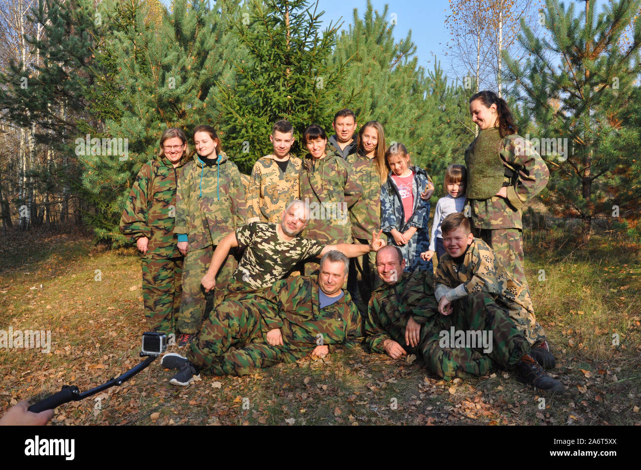 A group of young people of different ages and gender in camouflage clothes on the street. Photographing Stock Photo