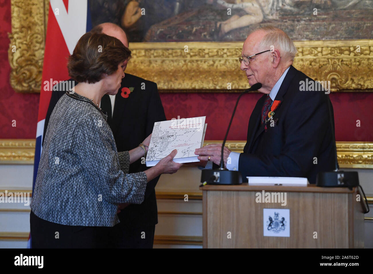 French Ambassador Catherine Colonna receives a gift from World War II veteran Geoffrey Pidgeon, who received the 6000th Legion d'honneur, for his role in the liberation of France during World War II, at a medal ceremony in Lancaster House in London. Stock Photo