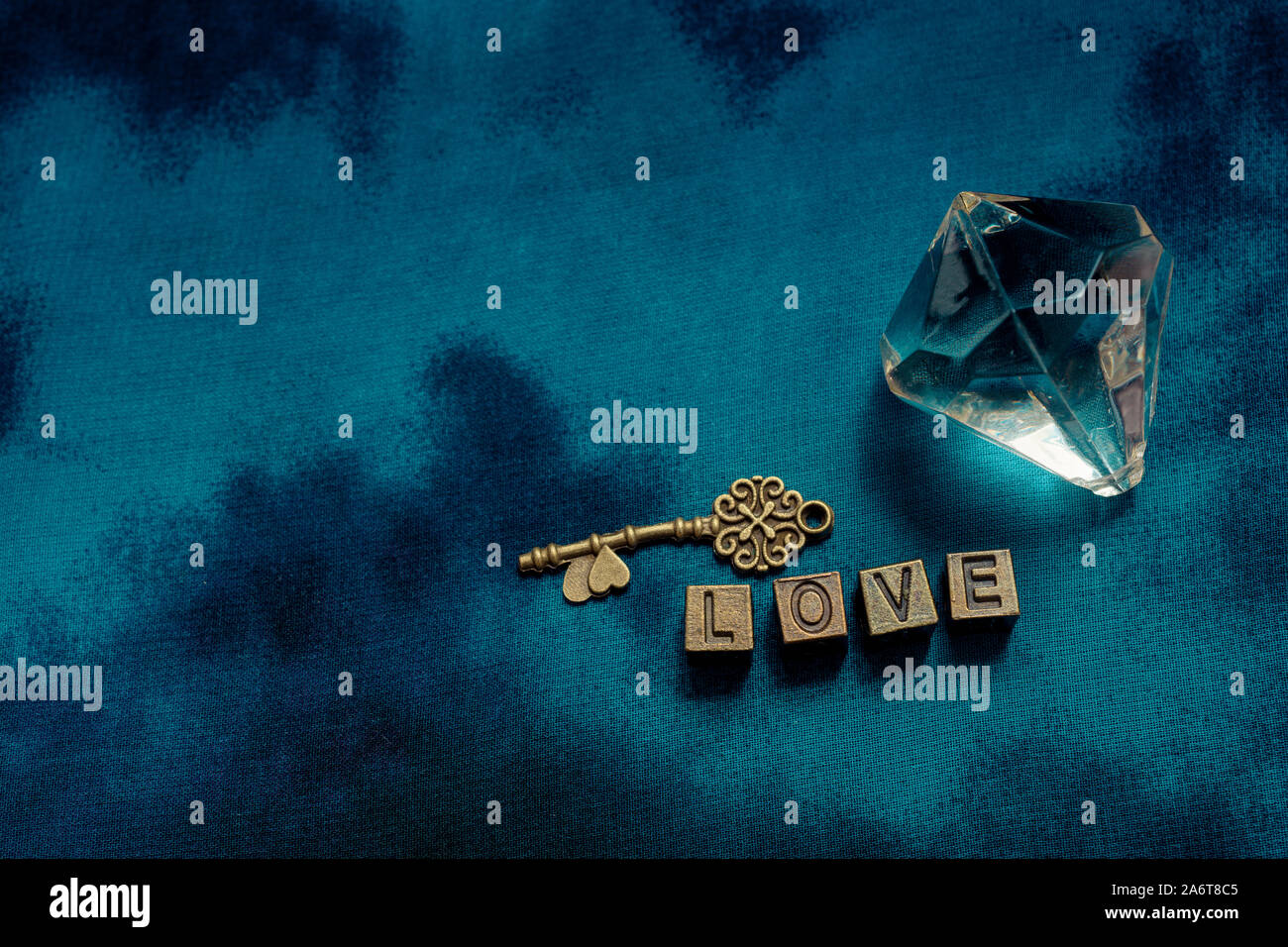 Ornamental key and fake diamond beside love wording with metal letters Stock Photo