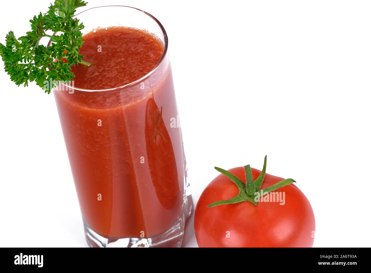 Healthy eating concept - juice from fresh tomatoes with parsley in glass next to a whole tomato isolated on a white background Stock Photo