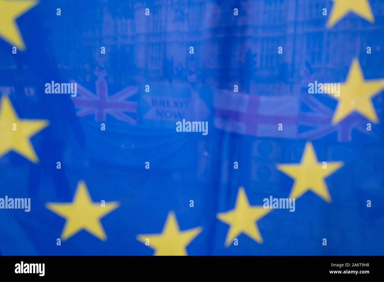 On the day that the EU in Brussels agreed in principle to extend Brexit until 31st January 2020 (aka 'Flextension') and not 31st October 2019, Brexit Party flags and banners are seen through an EU flag during a Brexit protest outside parliament, on 28th October 2019, in Westminster, London, England. Stock Photo