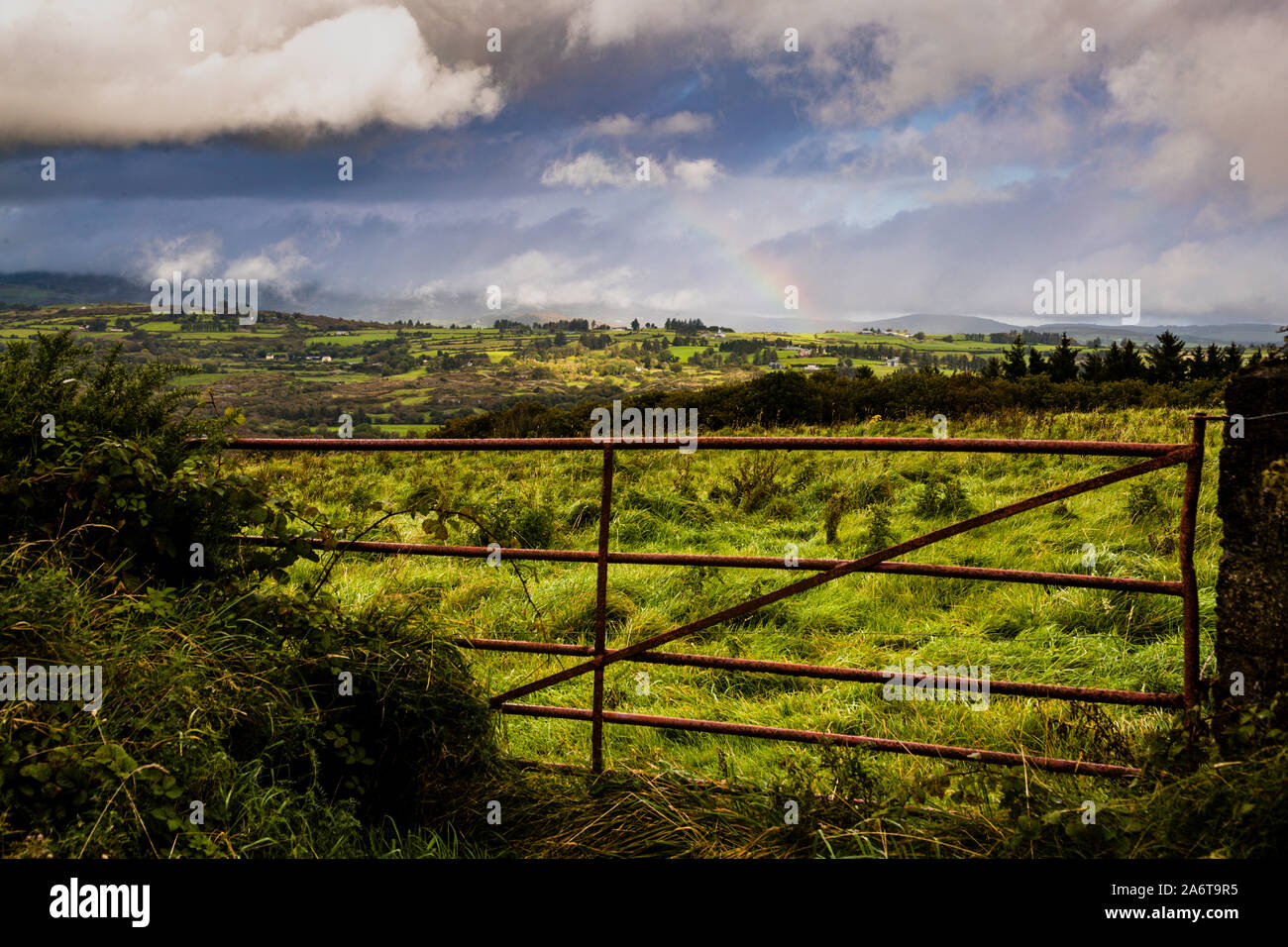 A rainbow arches over the green countryside near Macroom, County Cork, Ireland, on the drive from the "Toy Soldier Factory" (Prince August) in Kilnamartyra towards Killarney. Stock Photo