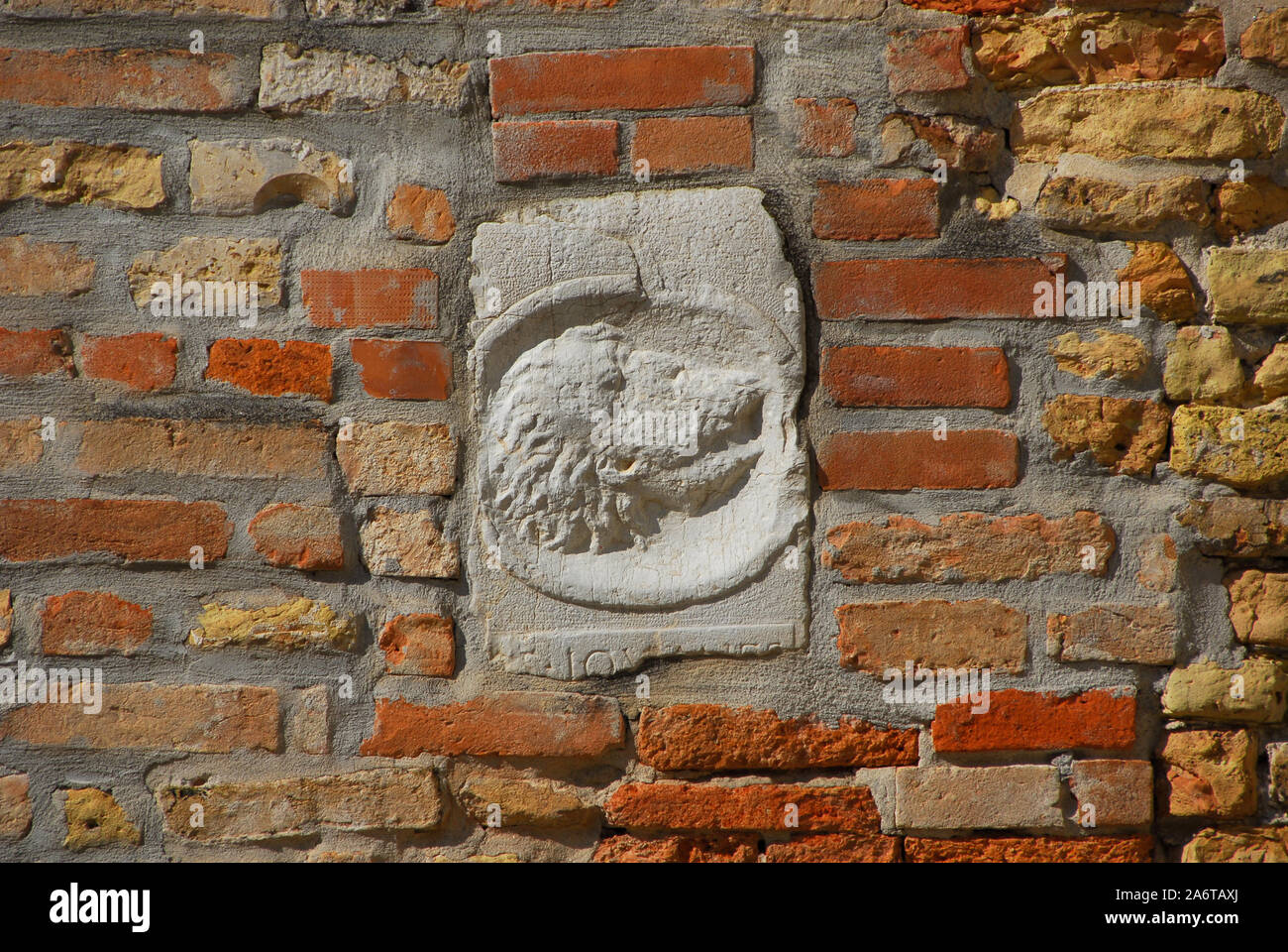Ancient medieval relief of head with long hair and beard on a Venice wall Stock Photo