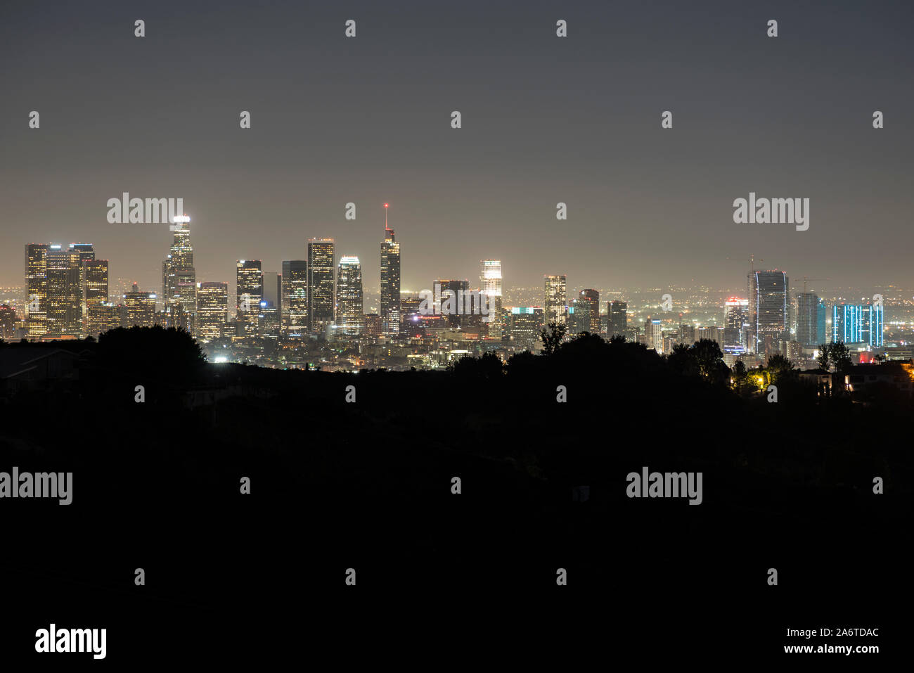 Night skyline view of downtown Los Angeles with hilltop ridgeline near Griffith Park in Southern California. Stock Photo