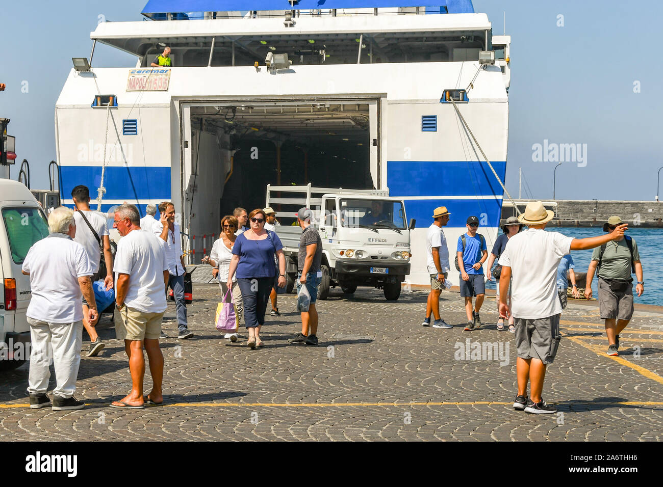 ISLE OF CAPRI, ITALY - AUGUST 2019: People and a vehicle disembarking a ferry in the port on the Isle of Capri. Stock Photo