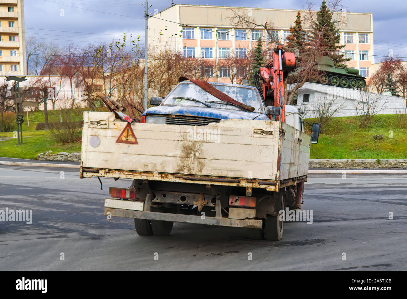 A car tow truck transports a damaged car through the city streets Stock