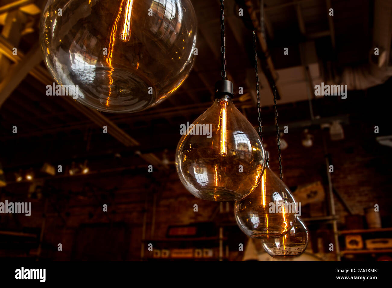 vintage large hanging glass lightbulbs with orange glow Stock Photo