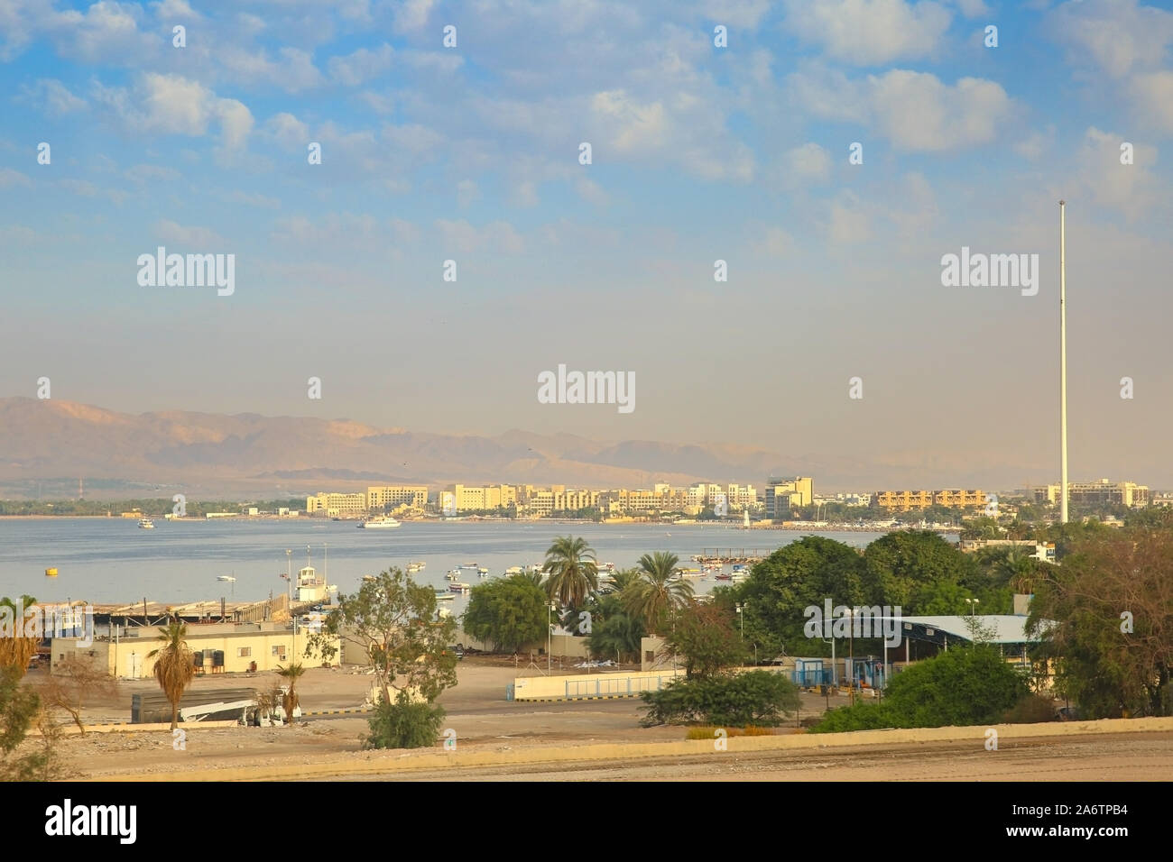 View of the Port City of Aqaba, Jordan. Buildings along the coastline with mountains in the background. Stock Photo