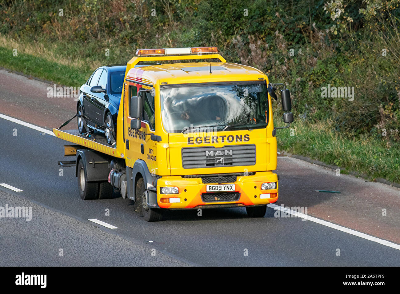 Egertons Breakdon Recovery;  Haulage delivery trucks, lorry, transportation, truck, cargo, MAN vehicle, delivery, commercial transport, industry, supply chain freight, on the M6 at Lancaster, UK Stock Photo