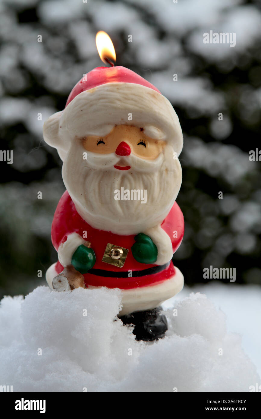 A santa claus candle burning outdoors on a winter day Stock Photo - Alamy