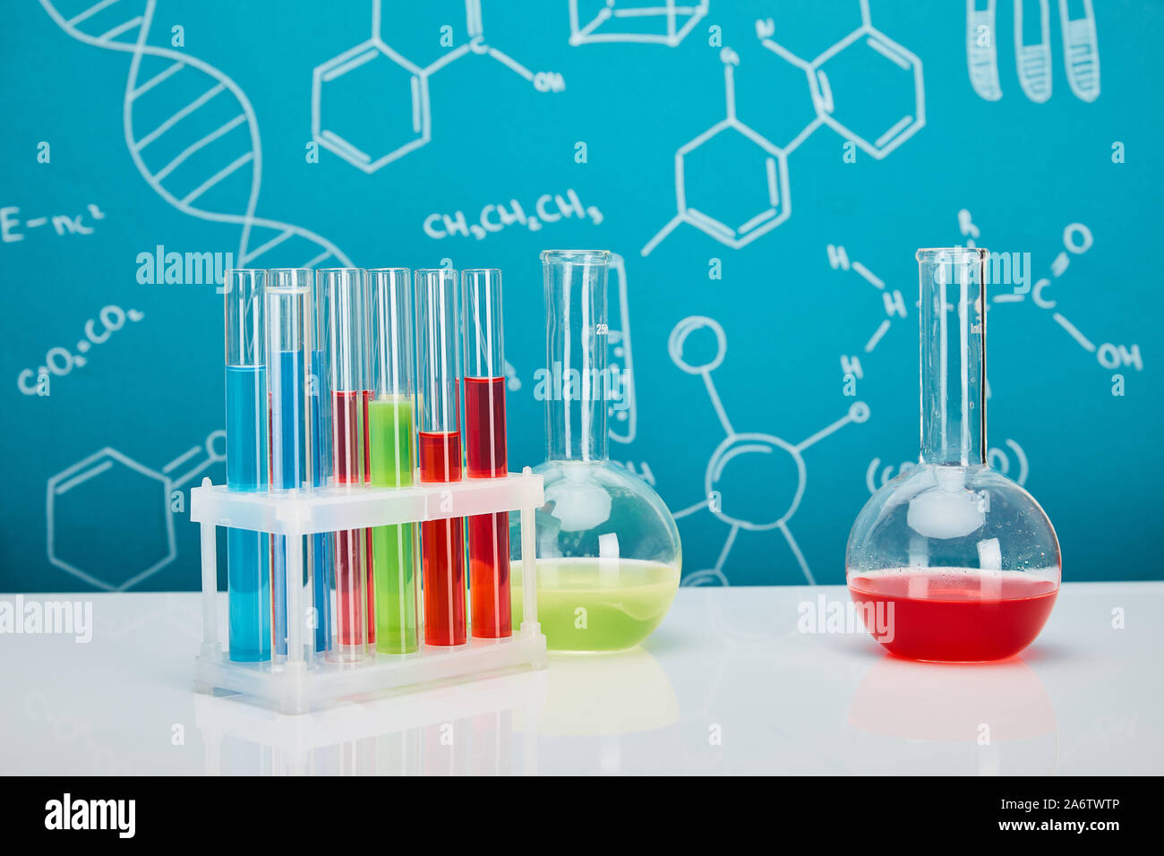 glass test tubes and flasks with colorful liquid on blue background ...