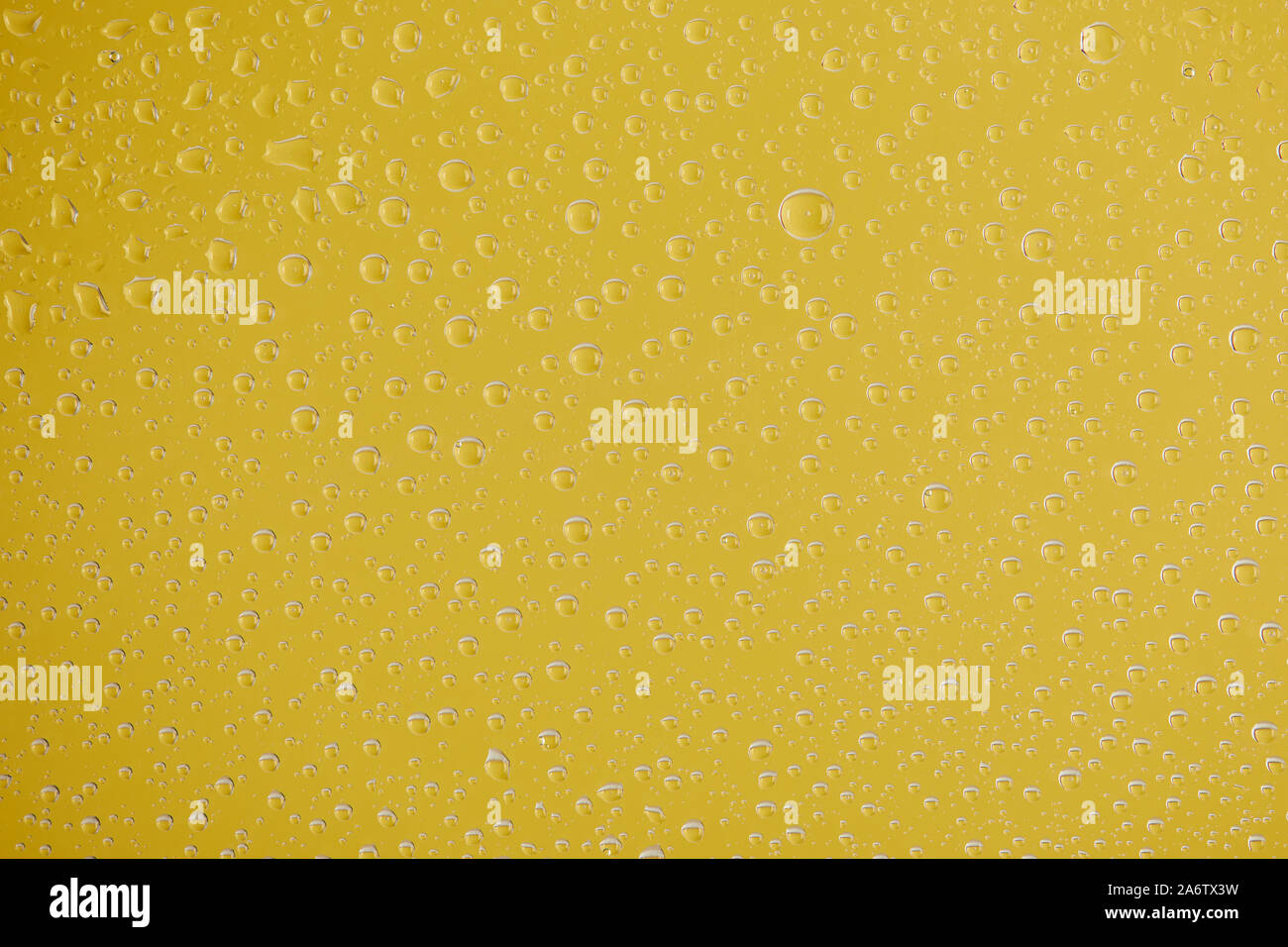 clear transparent water drops on yellow background Stock Photo - Alamy