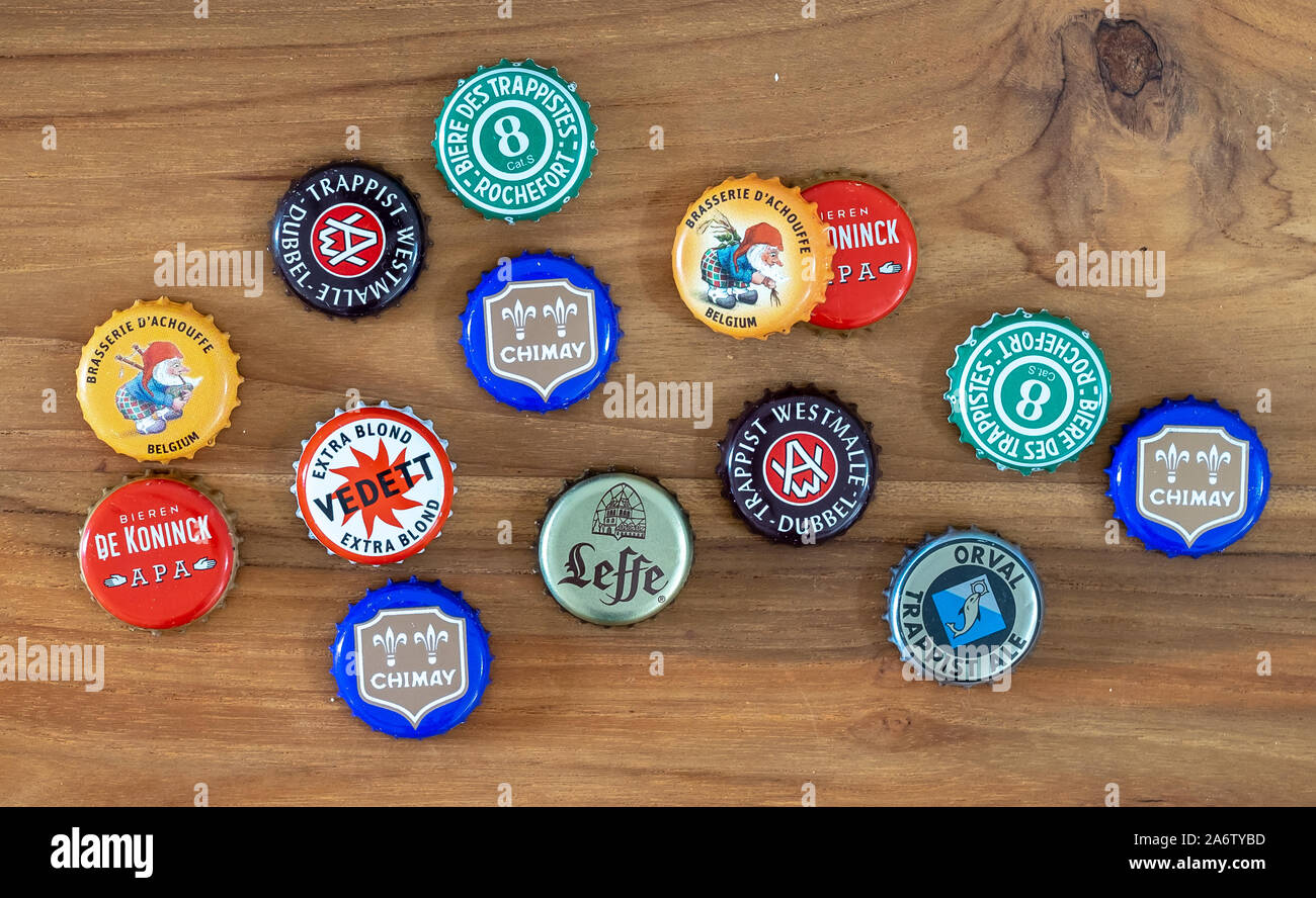 Beer caps of various traditional Belgian beers on old wooden table Stock Photo