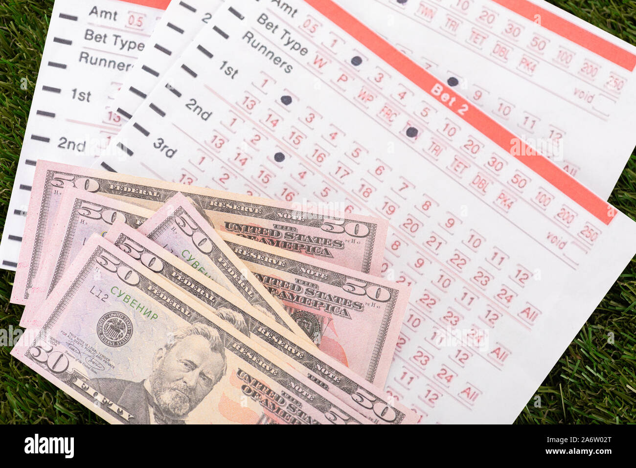 dollar banknotes and betting lists on green grass, sports betting concept Stock Photo