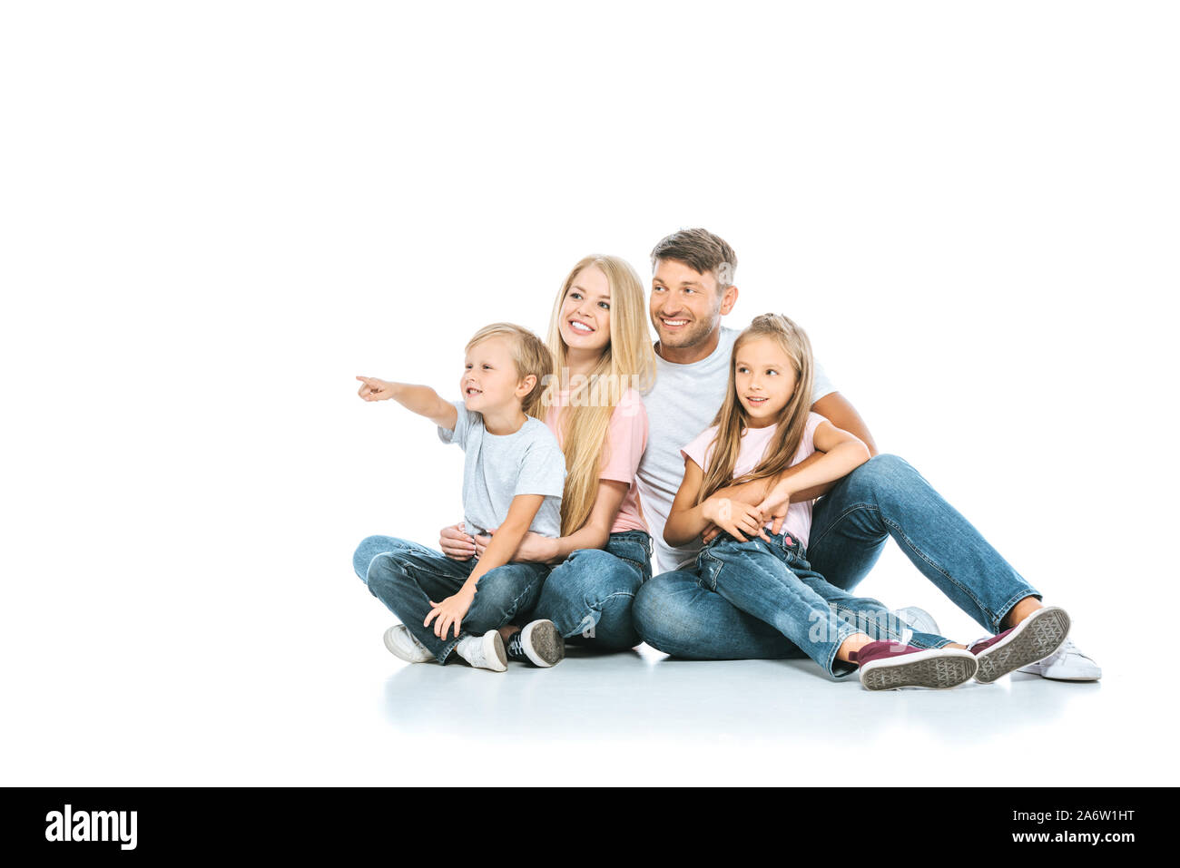 happy boy pointing with finger near sister and parents on white Stock Photo