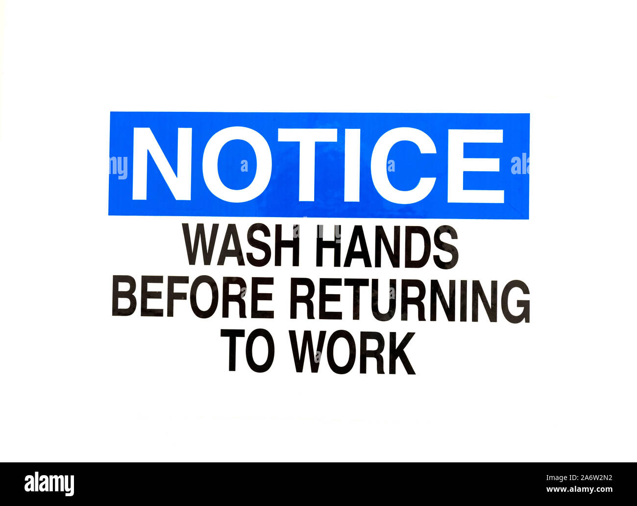 Sign on bathroom door for employees to wash their hands before returning to work. Stock Photo
