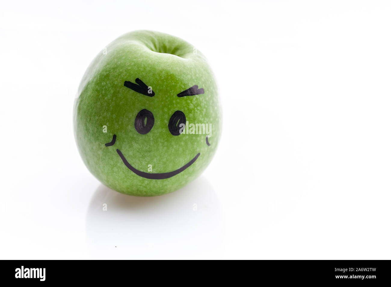 Face painted apple. Jolly funny green apple on a white background. Stock Photo