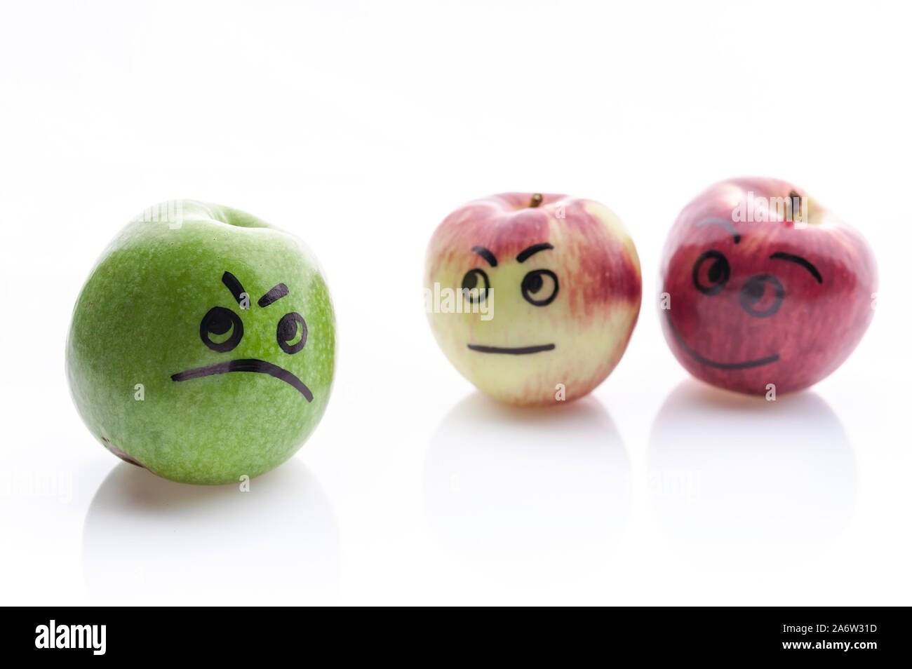Jolly and sad funny apples. Green and red apples on a white background. Stock Photo