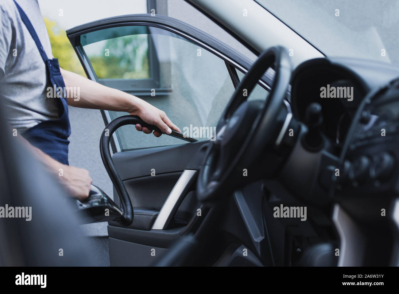 Cropped View Of Car Cleaner Vacuuming Drivers Seat In Car Stock