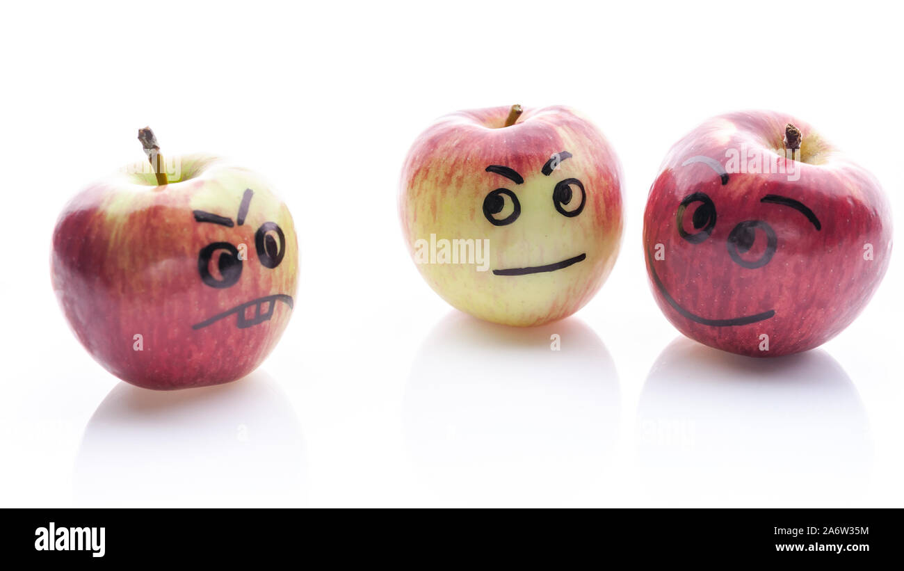 Face painted apples. Jolly and sad funny apples. Red apples on a white background. Stock Photo