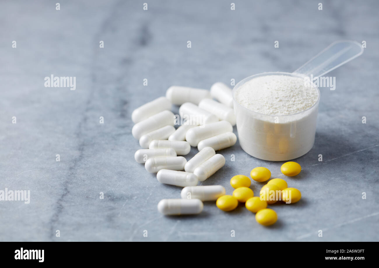 Proline and MSM (Sulfur) capsules and Vitamin C tablets to support collagen production. Bright stone background. Close up. Copy space. Stock Photo