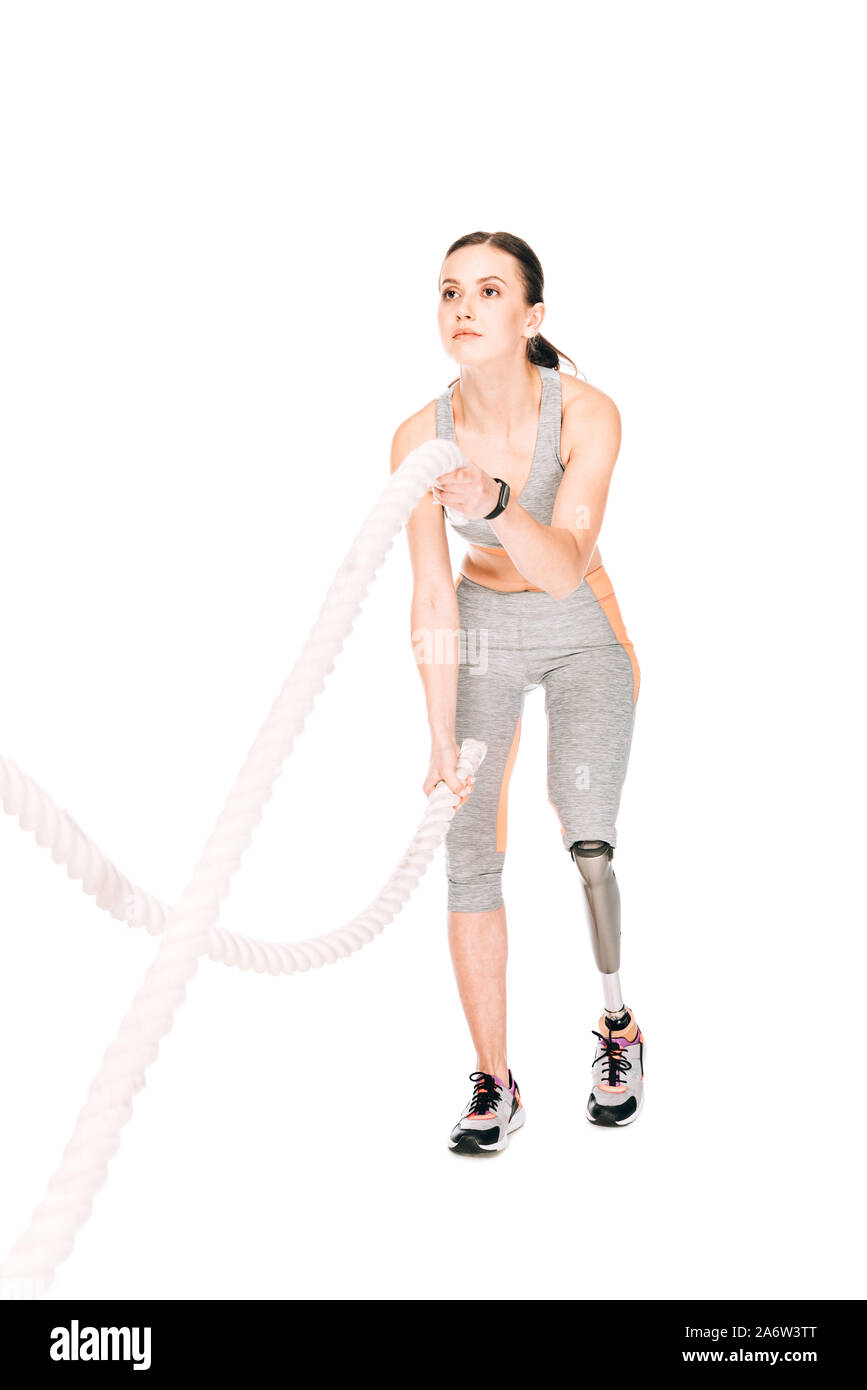 full length view of disabled sportswoman training with ropes isolated ...