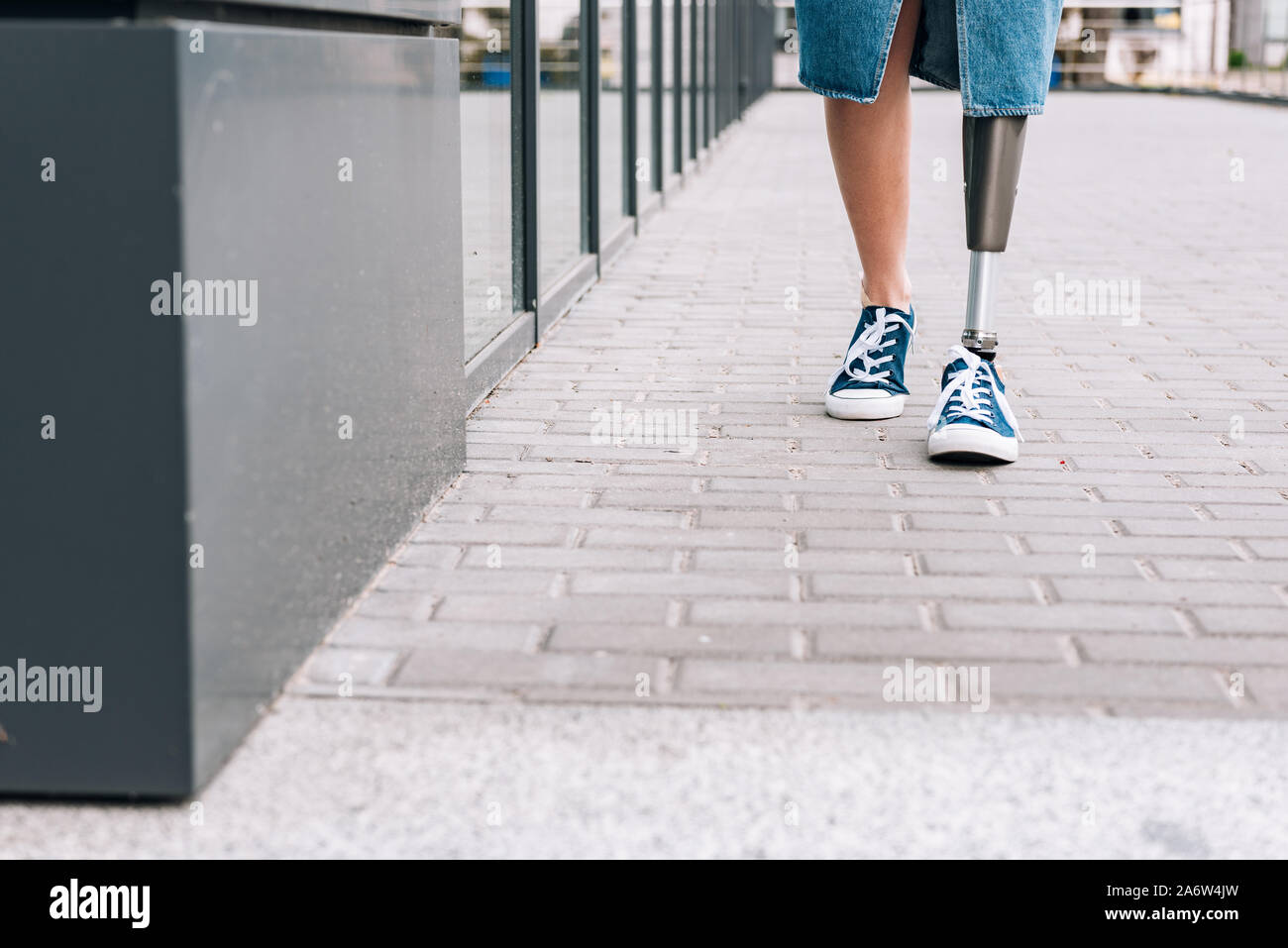 Cropped image of young disabled woman with prosthetic leg Stock