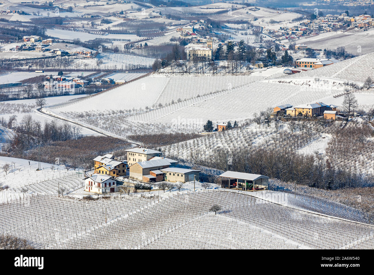 View from above an hamlets and villages among vineyards on the hills covered in snow in Piedmont, Northern Italy. Stock Photo